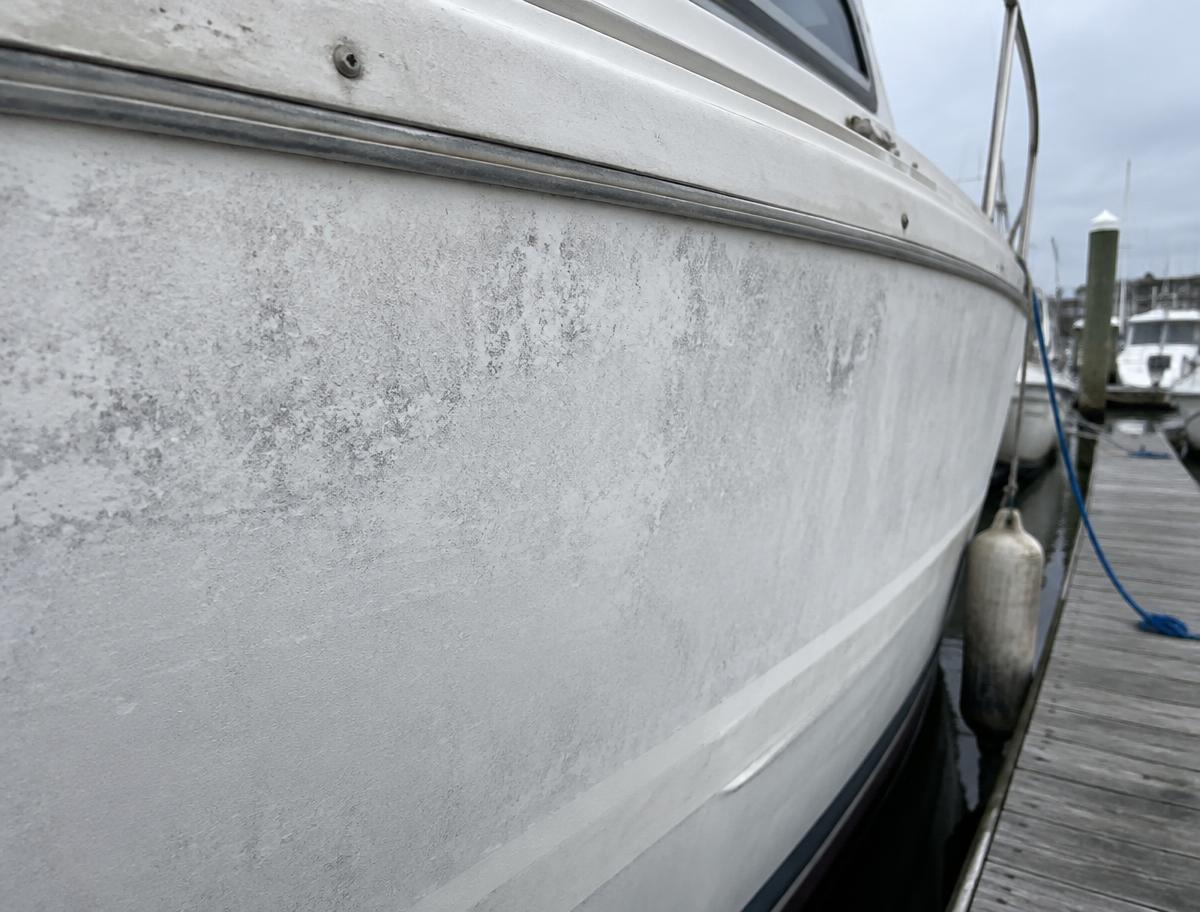 Oxidized, chalky white gelcoat on a boat hull before restoration